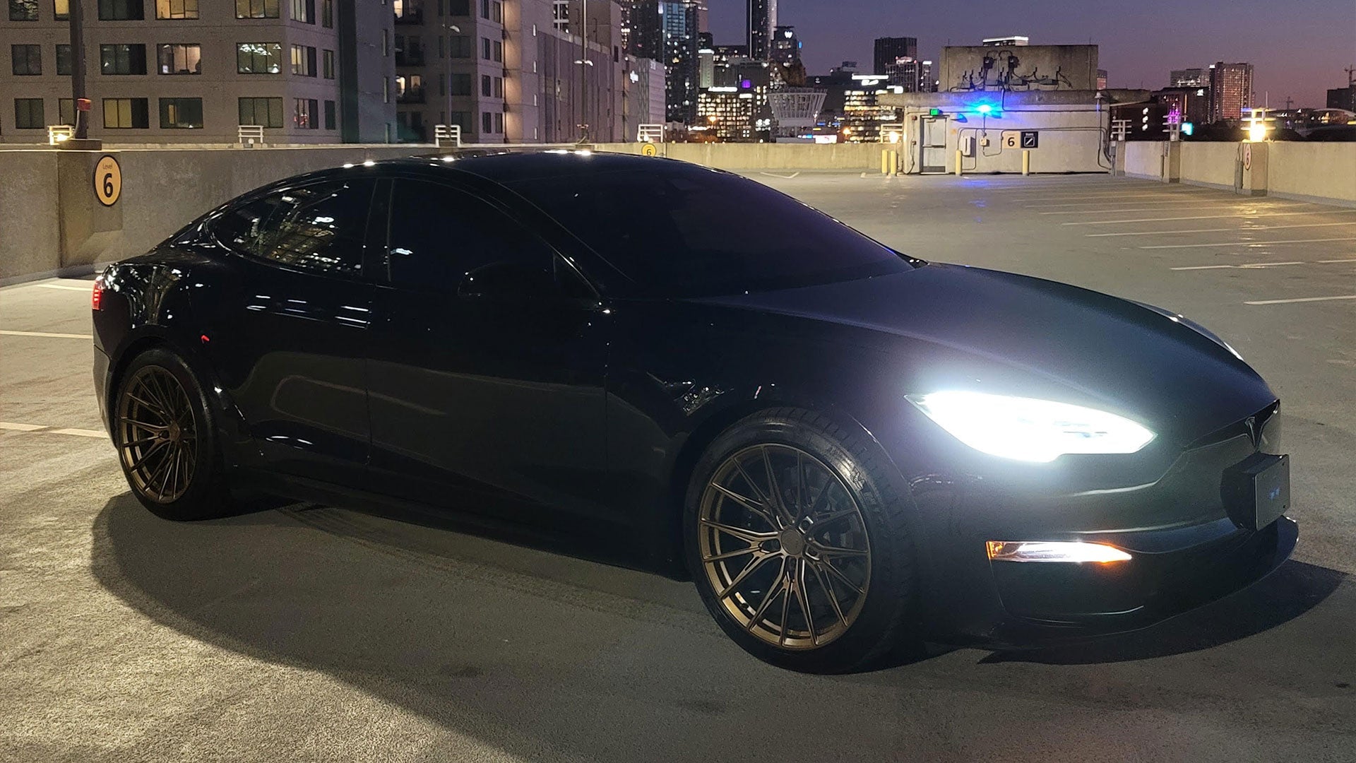 Detailed view of Tesla’s futuristic design paired with Satin Bronze Rian wheels